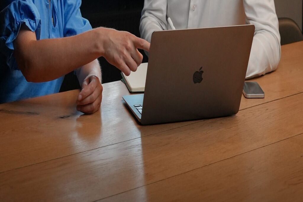 Twee collega's kijken samen naar een systeem op een laptop